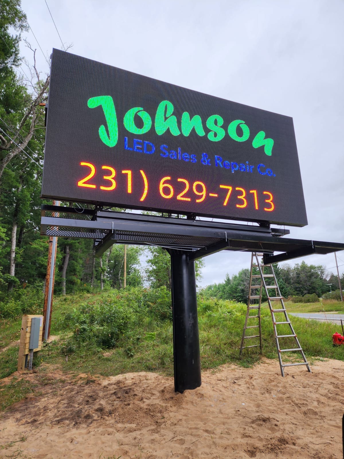 A large billboard sitting on top of a hill.