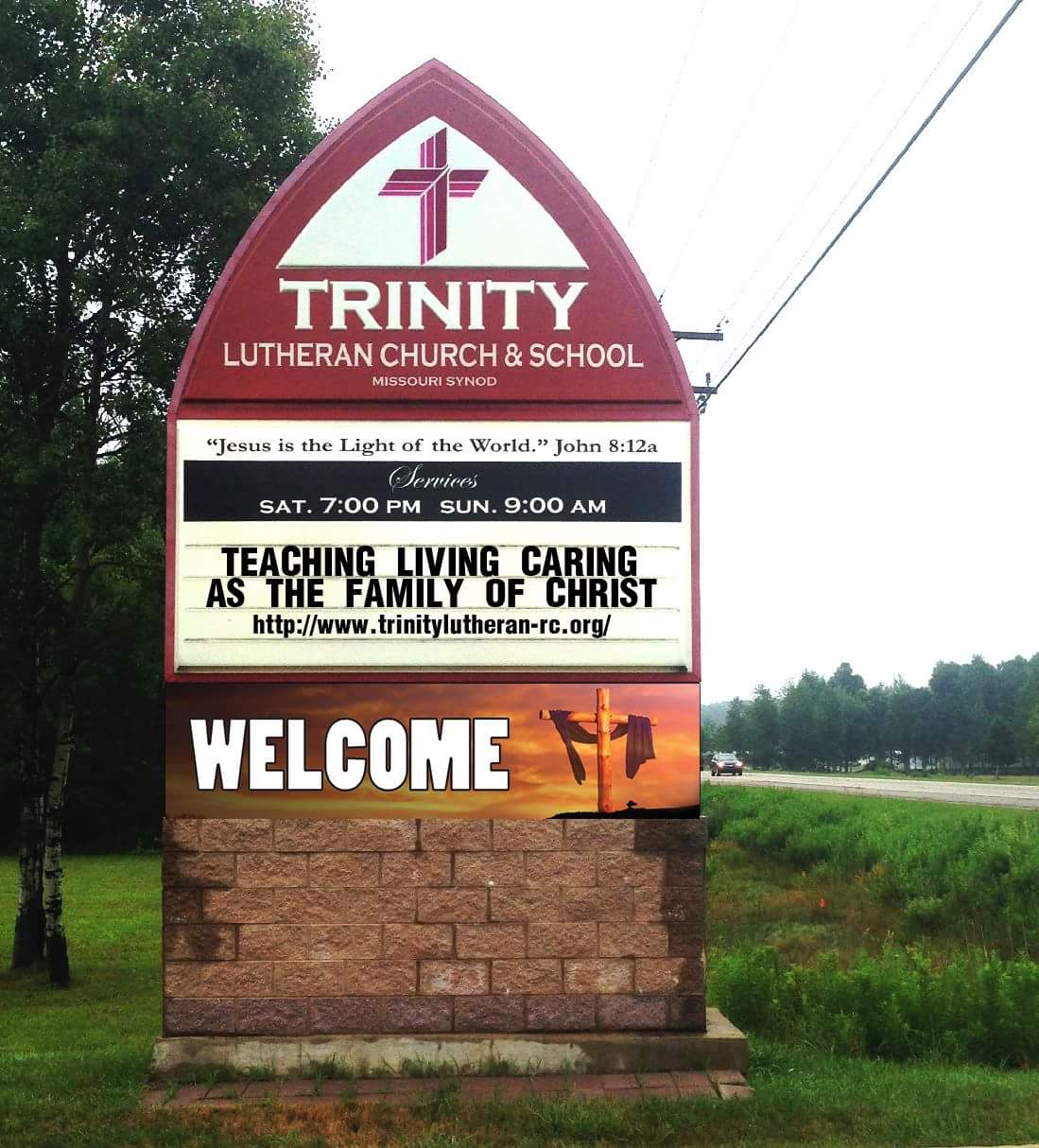 A sign that says " welcome " and " teaching living caring at the family of christ ".